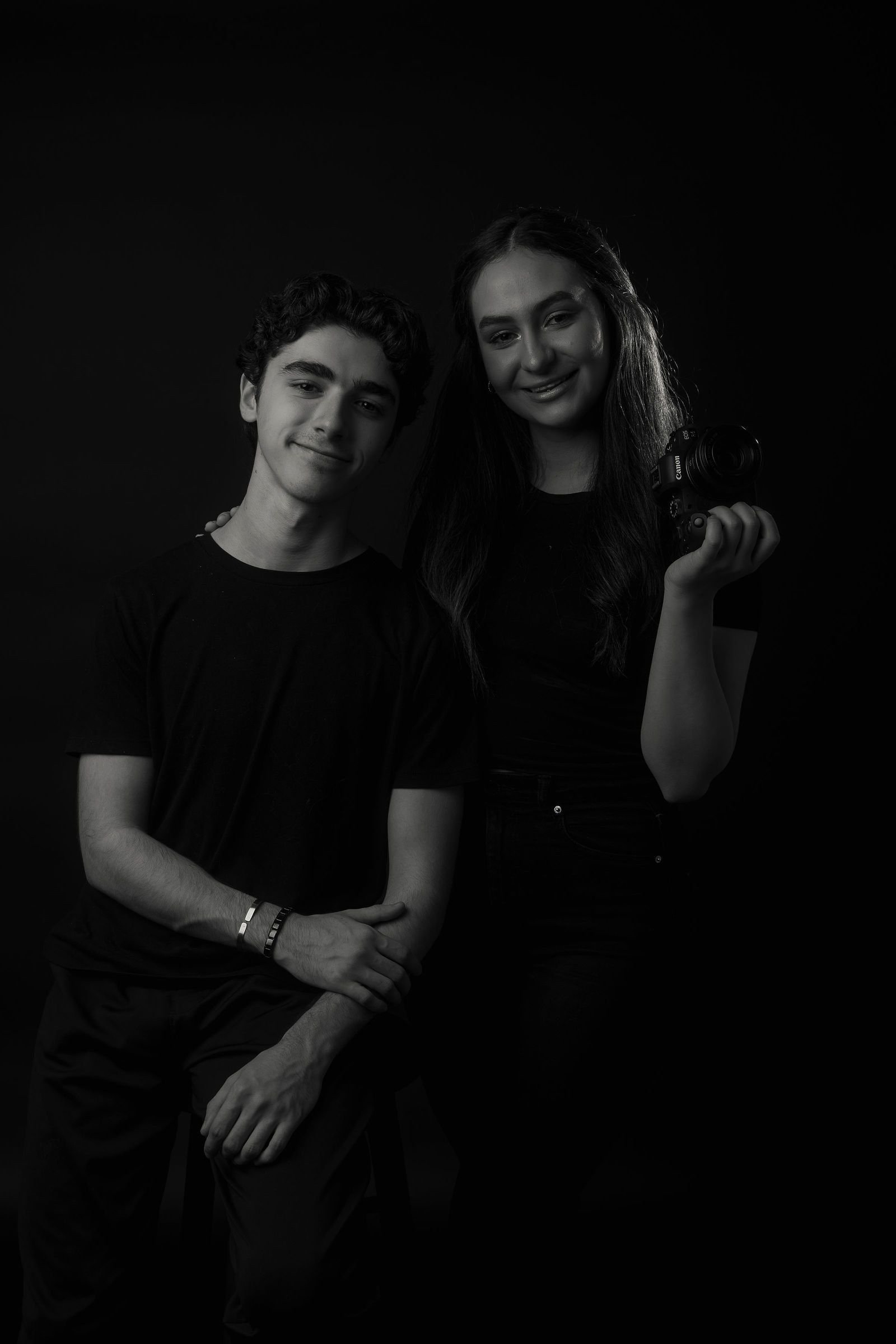 Damaris y Andrés, de Dream Studio, sobre fondo oscuro: él sonríe y ella sostiene una cámara.